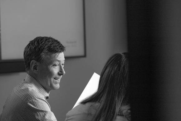 Intellecta2025_BK211226 Einar Þór Bjarnason að ræða við fundargest sem snýr bakinu í myndavélina og heldur á blöðum sem virðist broslegt, enda notar Intellecta ekki lengur pappír.